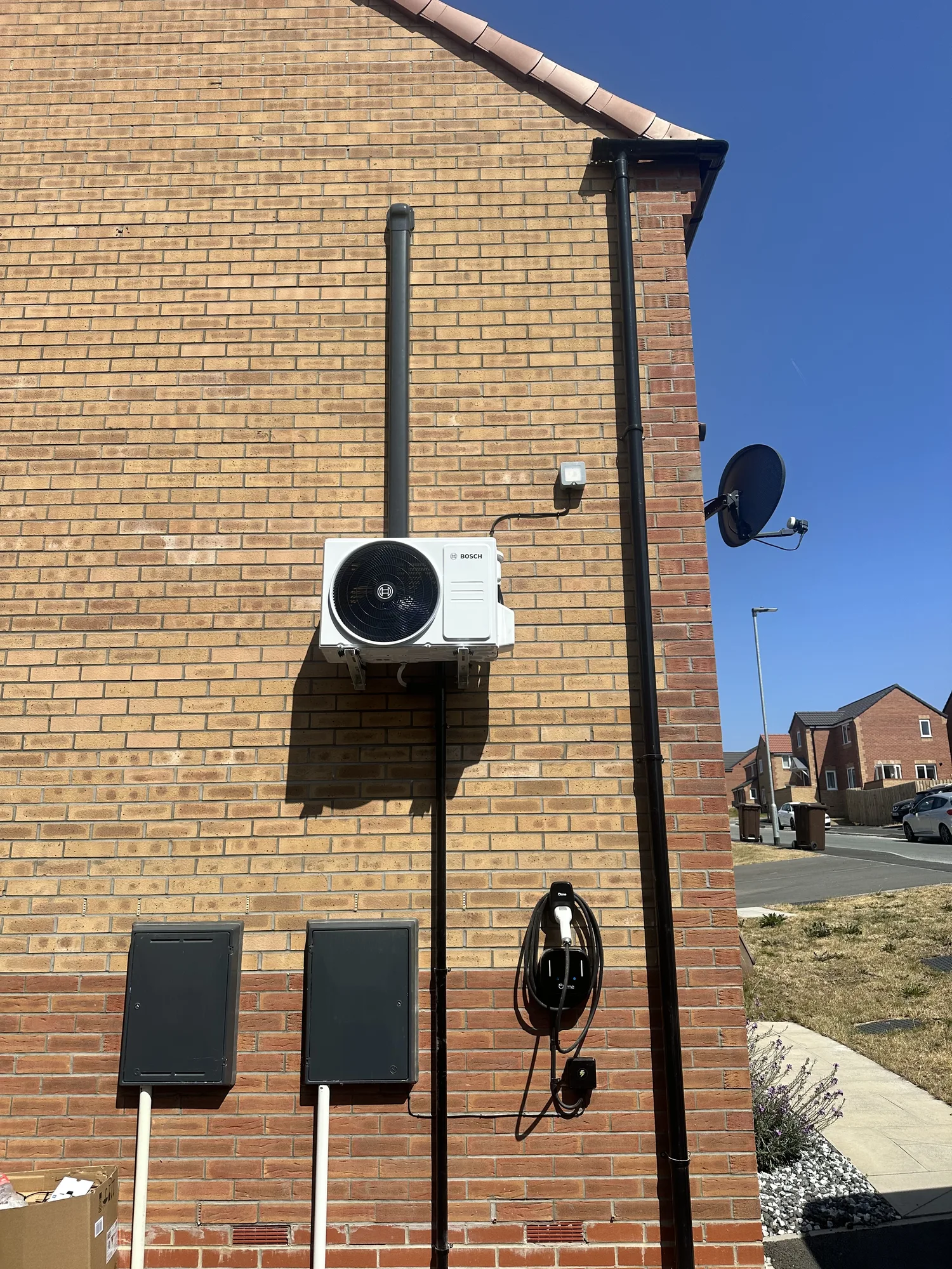 Air conditioning outdoor condenser wall-mounted on a brick gable