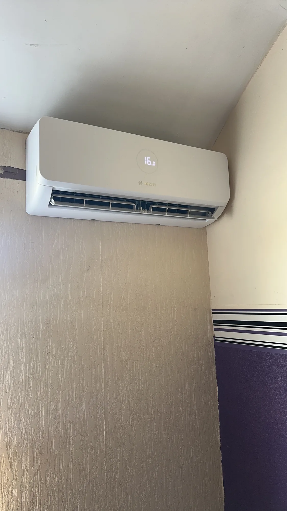 Wall-mounted air conditioning indoor split unit in a corner of a room
