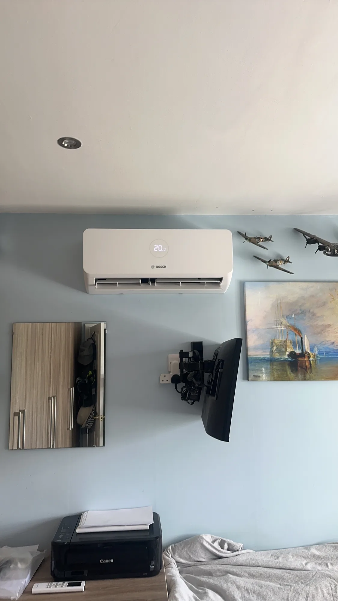 Wall-mounted air conditioning indoor split unit on a pale blue wall