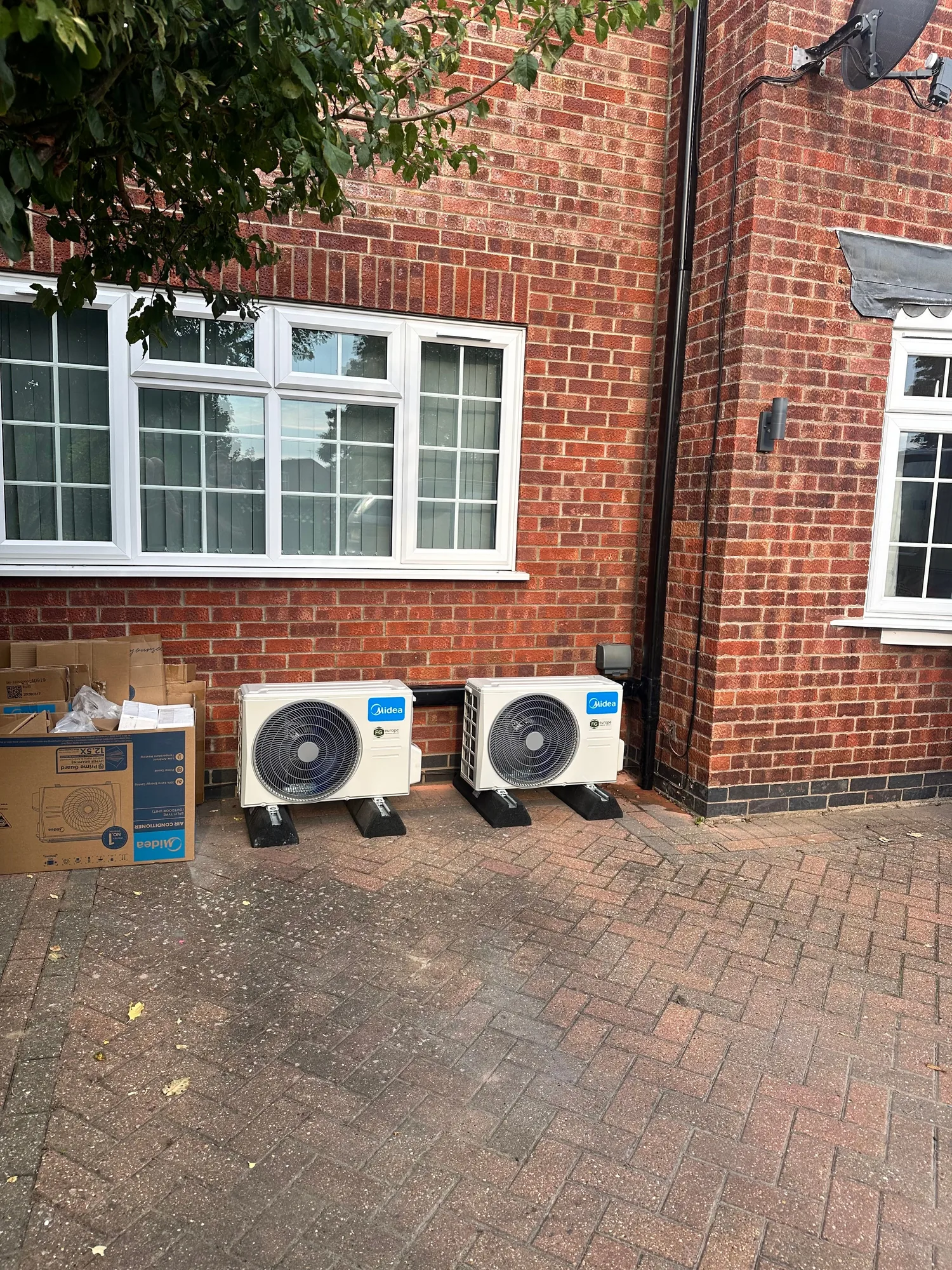 Two air conditioning condenser units installed on a patio