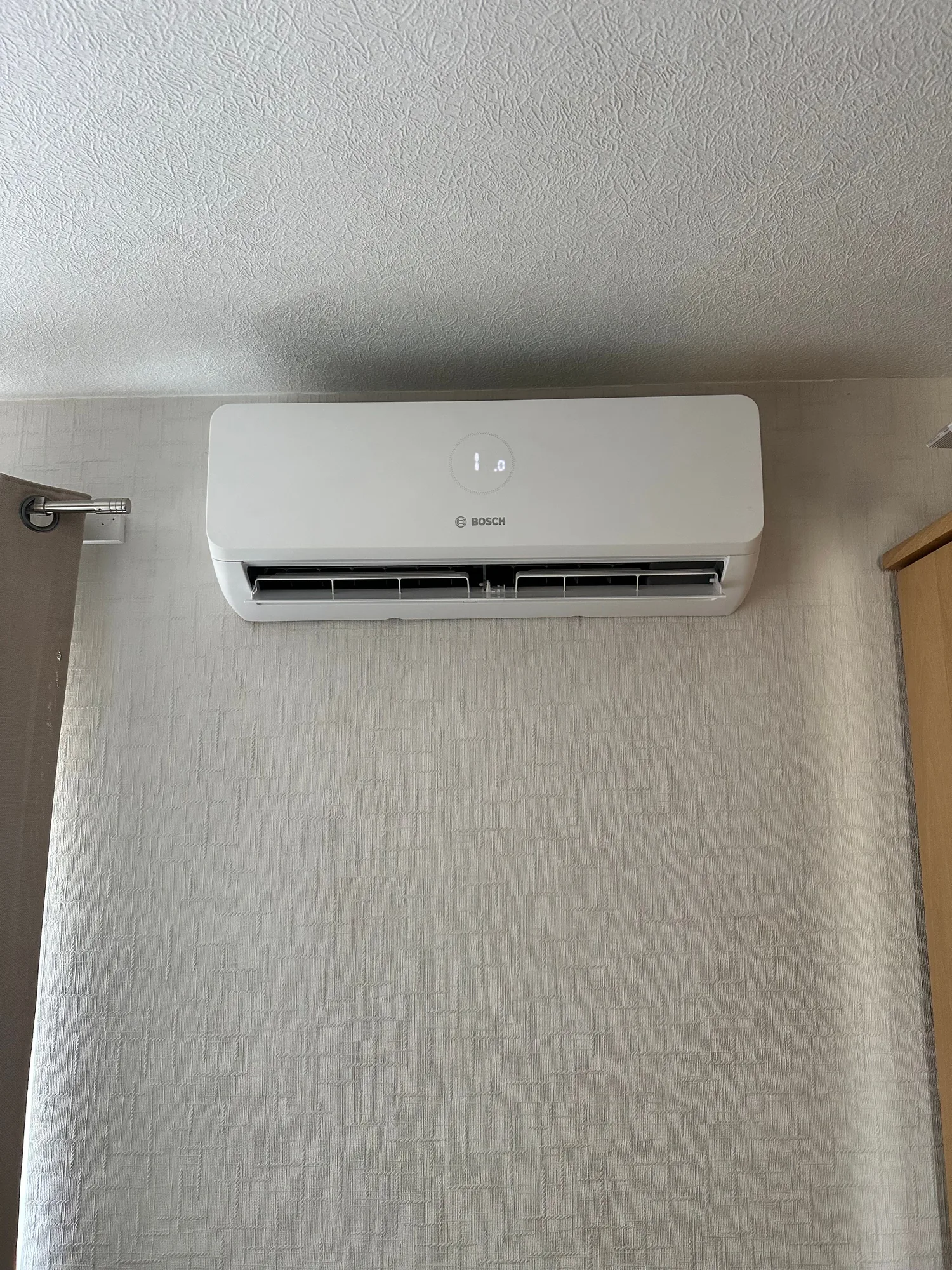 Bosch wall-mounted air conditioning indoor unit fitted neatly in a bedroom