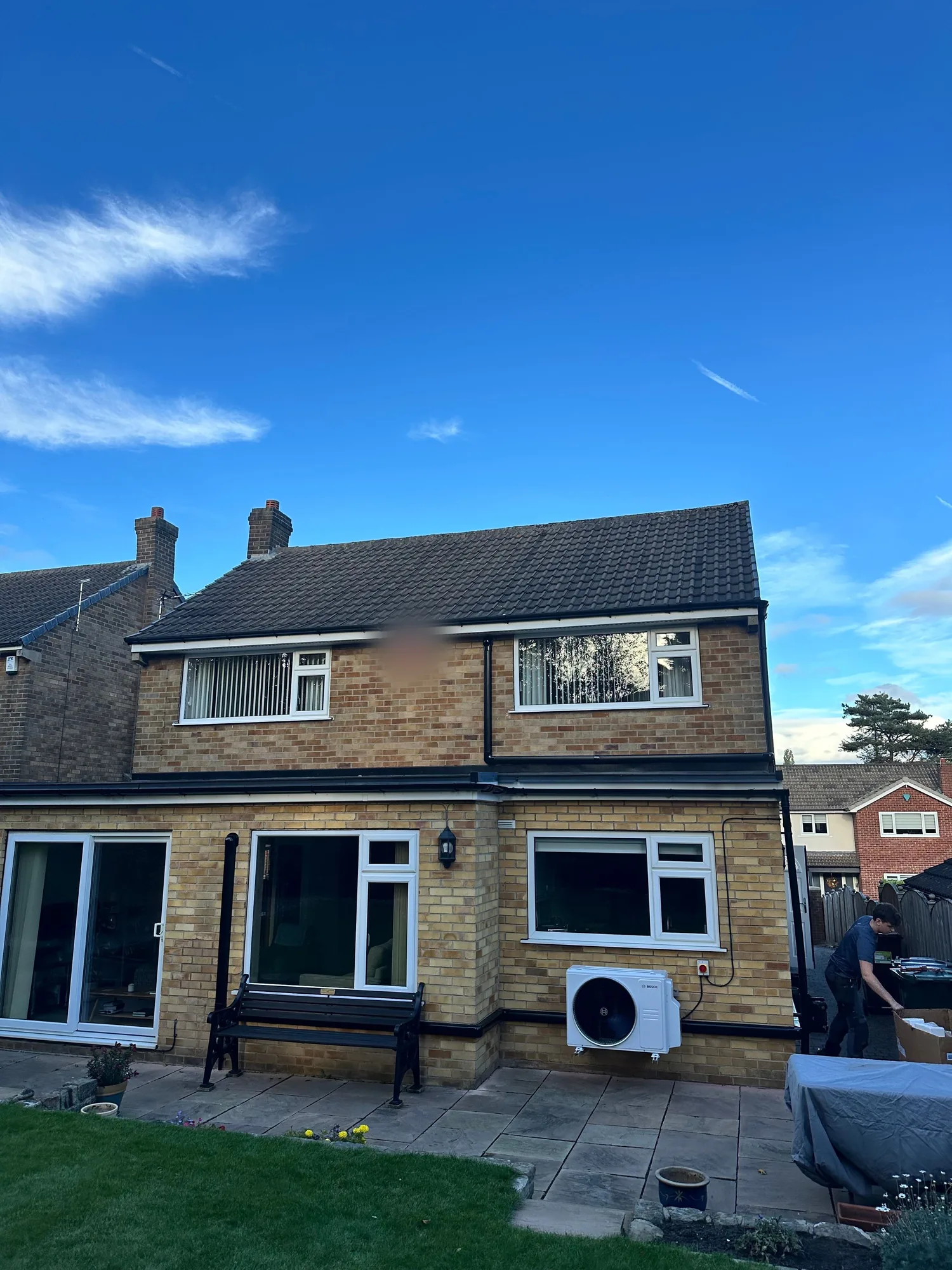 Bosch air conditioning condenser installed at the rear of a home, engineer on site