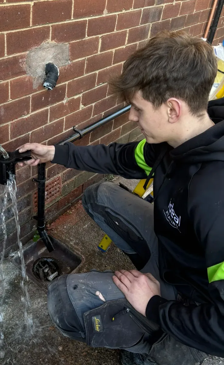 Sam, engineer at Fuzzy Duck PHC, working on external pipework